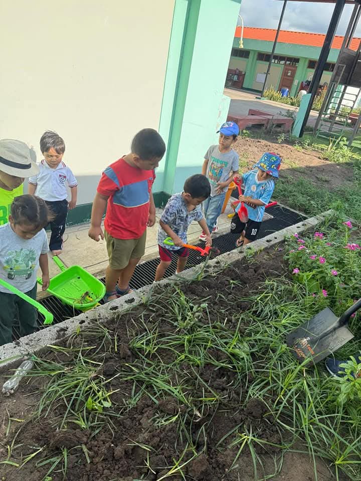Niños sembrando una planta en el jardín